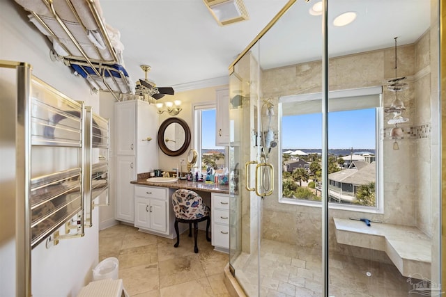 bathroom featuring vanity, a shower with door, and ornamental molding