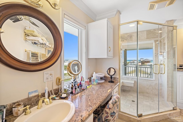 bathroom with walk in shower, a healthy amount of sunlight, and ornamental molding