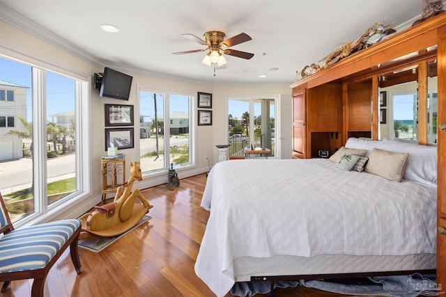 bedroom featuring light hardwood / wood-style floors, ceiling fan, and crown molding