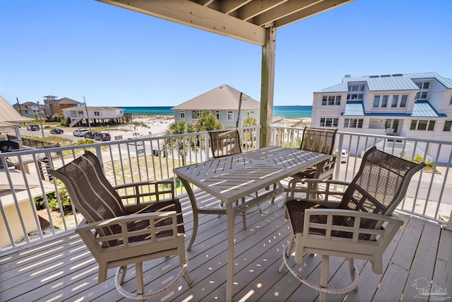 wooden deck featuring a view of the beach and a water view