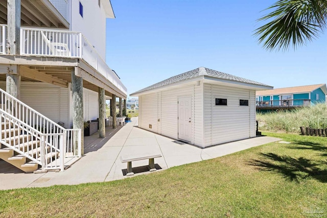 exterior space featuring a patio, an outdoor structure, and a lawn