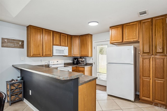 kitchen featuring kitchen peninsula, light tile patterned floors, white appliances, and sink