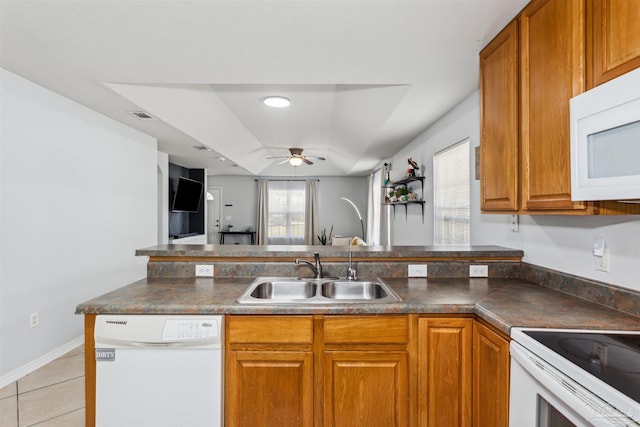 kitchen featuring white appliances, sink, ceiling fan, light tile patterned flooring, and kitchen peninsula