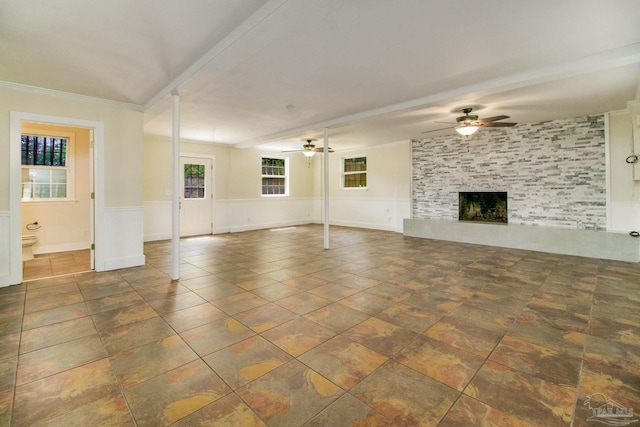 unfurnished living room with a large fireplace and ceiling fan