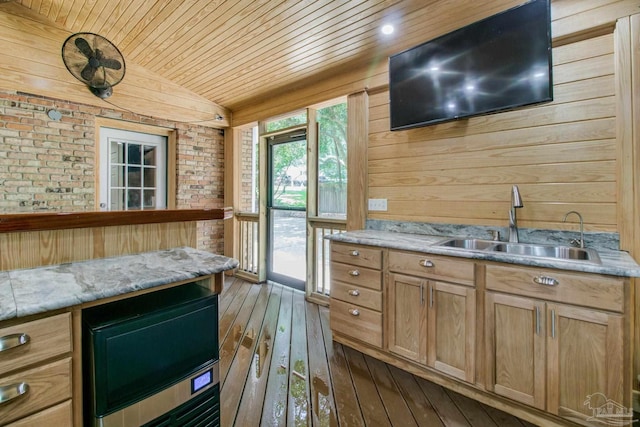 kitchen with dark wood-type flooring, lofted ceiling, sink, wood walls, and wood ceiling