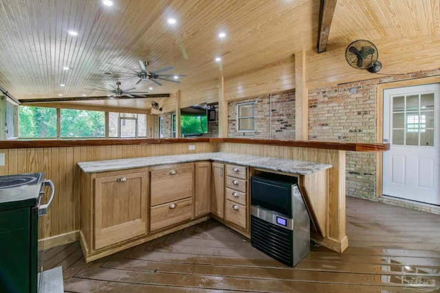 kitchen featuring dark wood-type flooring, wooden walls, kitchen peninsula, and stainless steel stove