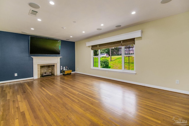 unfurnished living room with wood-type flooring and a fireplace