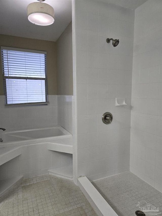 bathroom featuring tile patterned flooring, a tile shower, and a bath