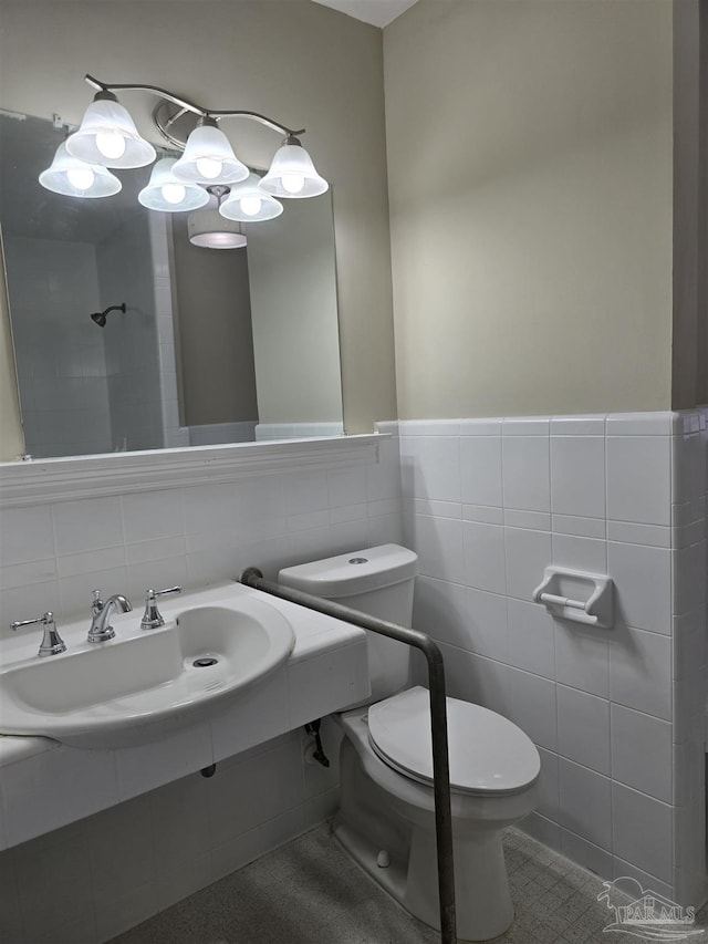 bathroom with toilet, a sink, and tile walls