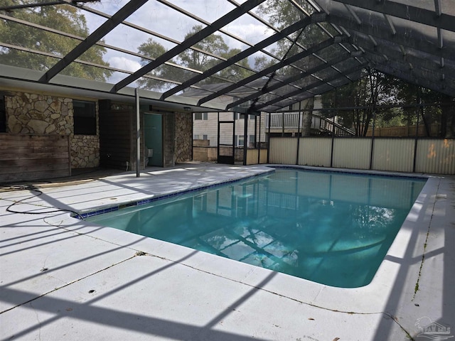 view of swimming pool with a patio, glass enclosure, fence, and a fenced in pool