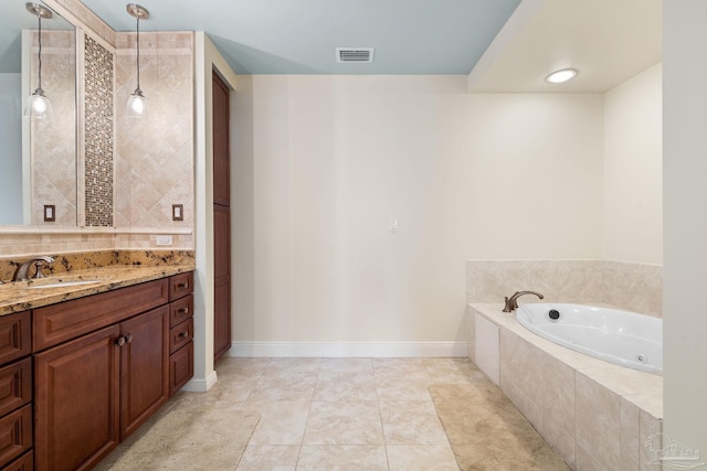 bathroom featuring tile patterned flooring, vanity, and a relaxing tiled tub