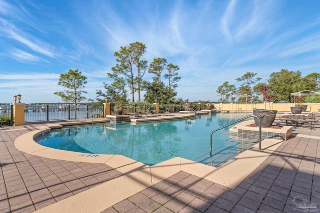 view of pool featuring a patio and a water view