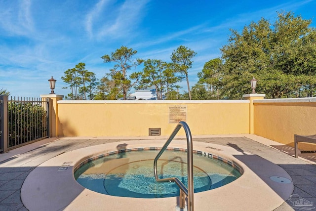 view of swimming pool with a hot tub