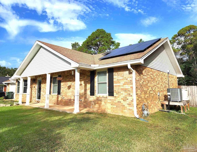 exterior space featuring solar panels, a front lawn, covered porch, and cooling unit