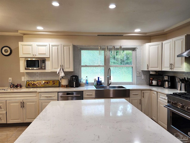 kitchen with light stone countertops, stainless steel appliances, ornamental molding, and sink