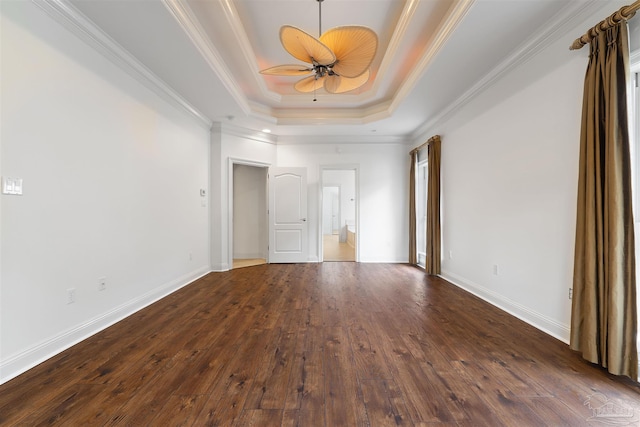 unfurnished room with ornamental molding, dark wood-type flooring, a raised ceiling, and ceiling fan