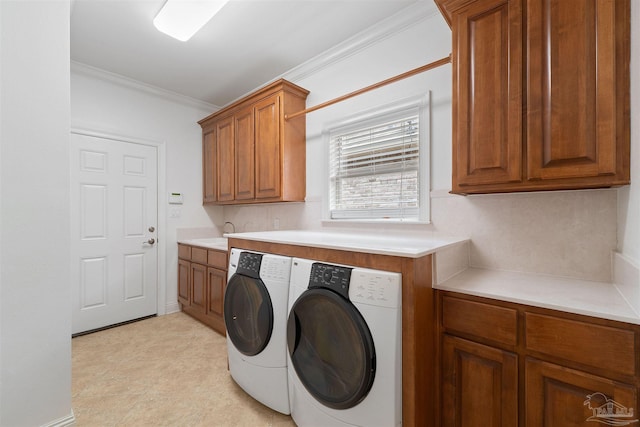 washroom featuring sink, crown molding, washer and dryer, and cabinets