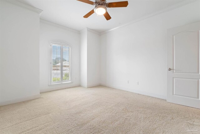 empty room featuring ornamental molding, carpet flooring, and ceiling fan