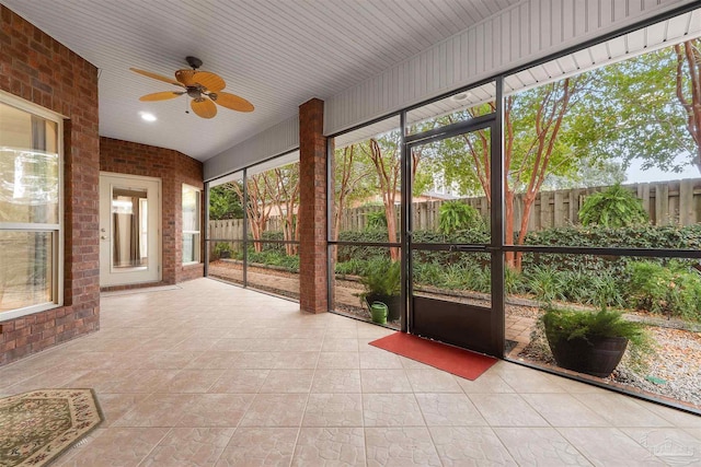 unfurnished sunroom with ceiling fan