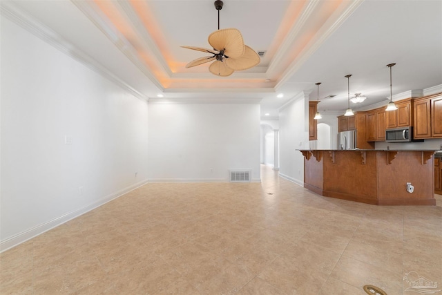 unfurnished living room featuring ornamental molding, a raised ceiling, and ceiling fan