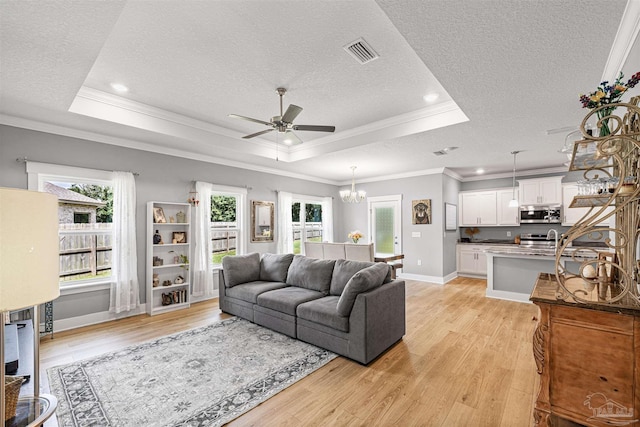 1223 Fenwick Ct, Cantonment, FL 32533 - living area with a raised ceiling, a textured ceiling, a ceiling fan, light wood finished floors, and ornamental molding