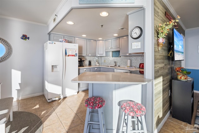 24230 Perdido Beach Blvd Unit 3087, Orange Beach, AL 36561 - kitchen featuring gray cabinetry, white appliances, crown molding, light tile patterned floors, and a breakfast bar area