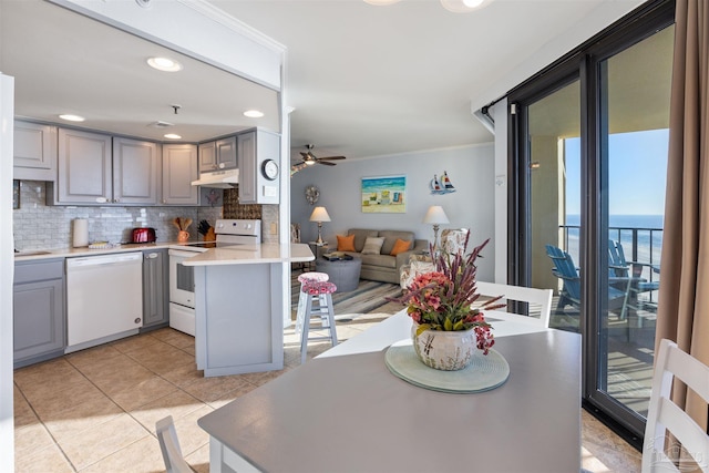 24230 Perdido Beach Blvd Unit 3087, Orange Beach, AL 36561 - kitchen featuring kitchen peninsula, backsplash, gray cabinetry, white appliances, and a water view
