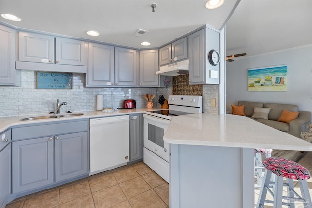 24230 Perdido Beach Blvd Unit 3087, Orange Beach, AL 36561 - kitchen with kitchen peninsula, white appliances, sink, light tile patterned floors, and gray cabinets