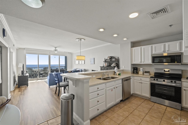 kitchen with sink, white cabinets, appliances with stainless steel finishes, and kitchen peninsula