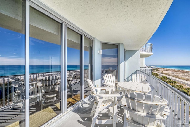 balcony featuring a beach view and a water view