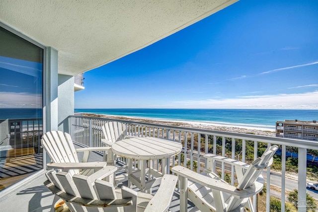 balcony featuring a water view and a beach view