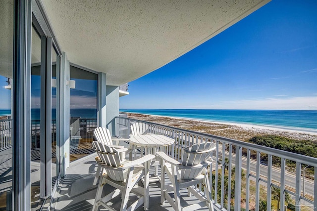 balcony featuring a beach view and a water view