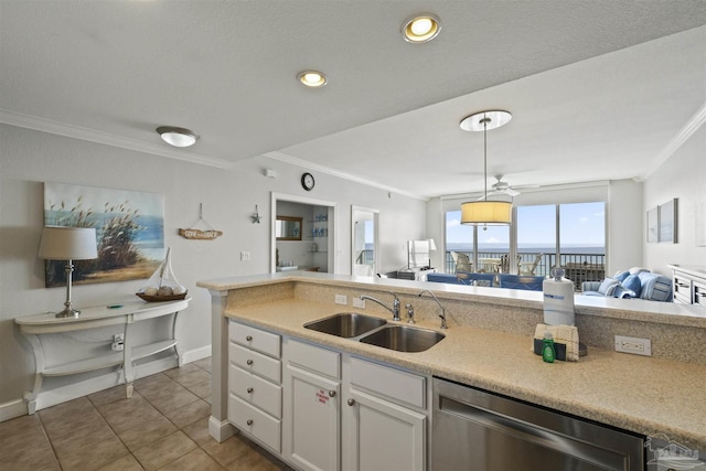 kitchen with hanging light fixtures, ornamental molding, stainless steel dishwasher, white cabinets, and sink