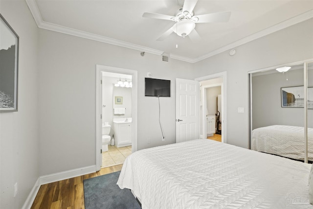 bedroom featuring ceiling fan, crown molding, ensuite bathroom, and hardwood / wood-style flooring