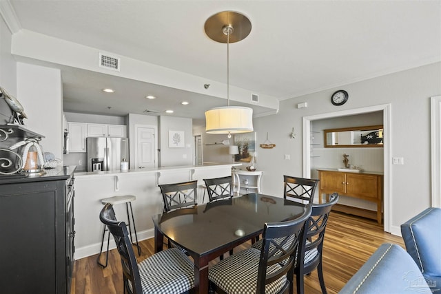 dining room with ornamental molding and hardwood / wood-style floors