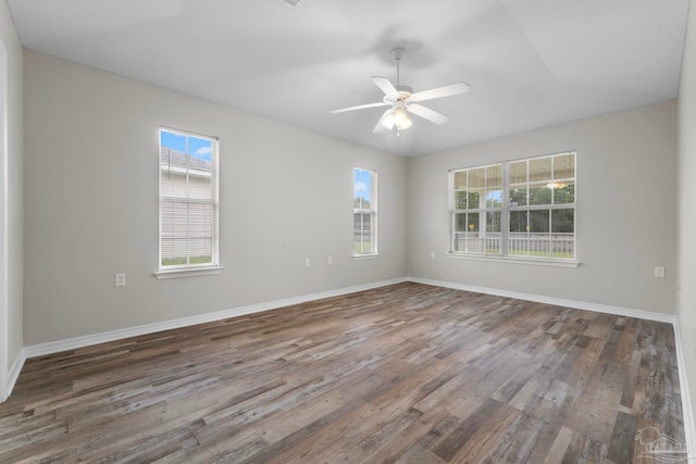 spare room featuring dark hardwood / wood-style flooring, ceiling fan, and a wealth of natural light