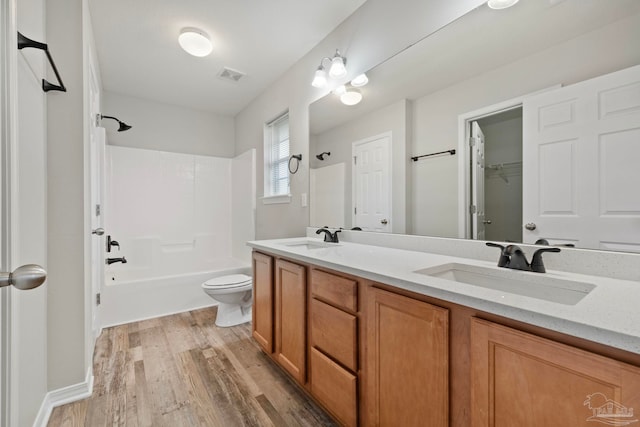 full bathroom featuring shower / tub combination, wood-type flooring, vanity, and toilet