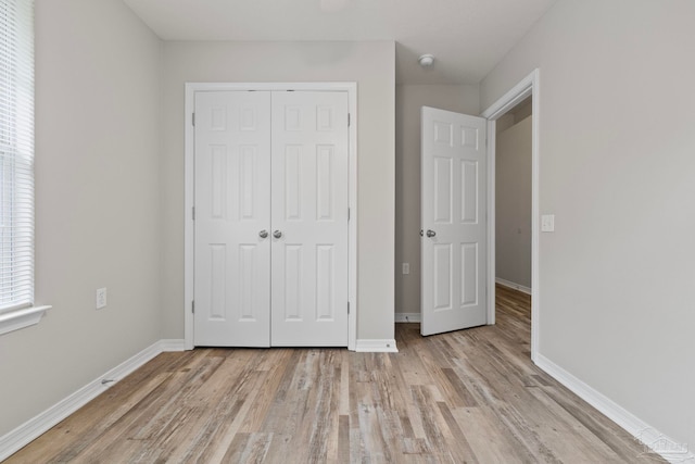 unfurnished bedroom featuring a closet and light wood-type flooring