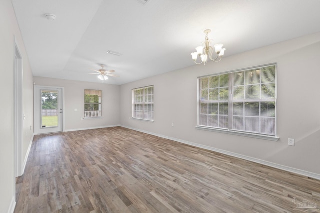 unfurnished room featuring ceiling fan with notable chandelier and light hardwood / wood-style flooring