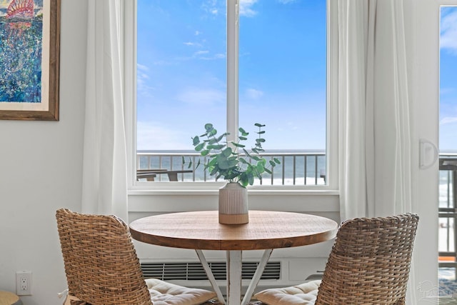dining area with a water view, a healthy amount of sunlight, and breakfast area