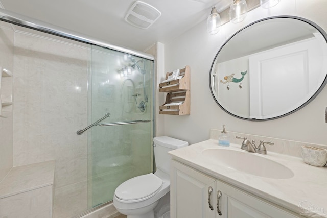bathroom with toilet, vanity, a stall shower, and visible vents