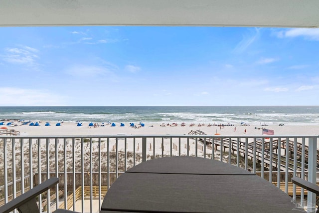 balcony featuring a beach view and a water view