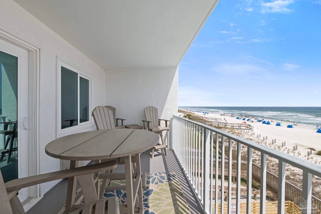 balcony with a water view and a view of the beach