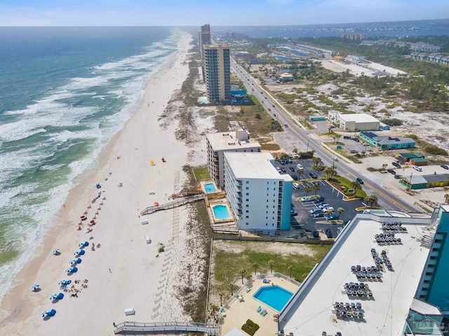 bird's eye view with a water view, a view of the beach, and a city view
