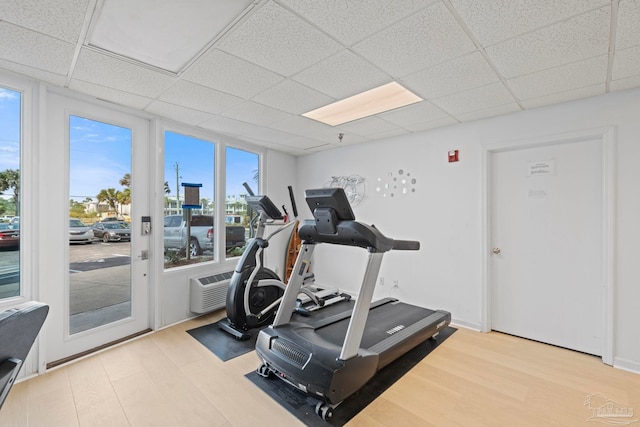 workout area featuring wood finished floors and a paneled ceiling
