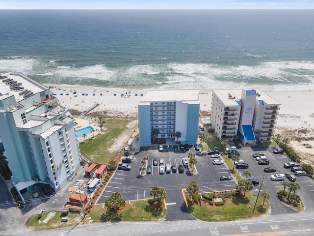 drone / aerial view with a water view and a beach view
