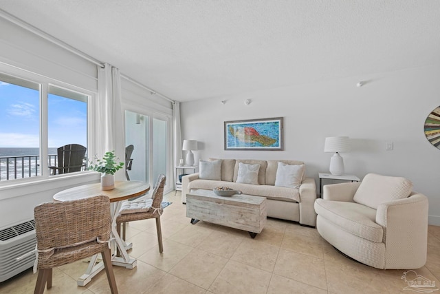 living area featuring a textured ceiling and light tile patterned floors