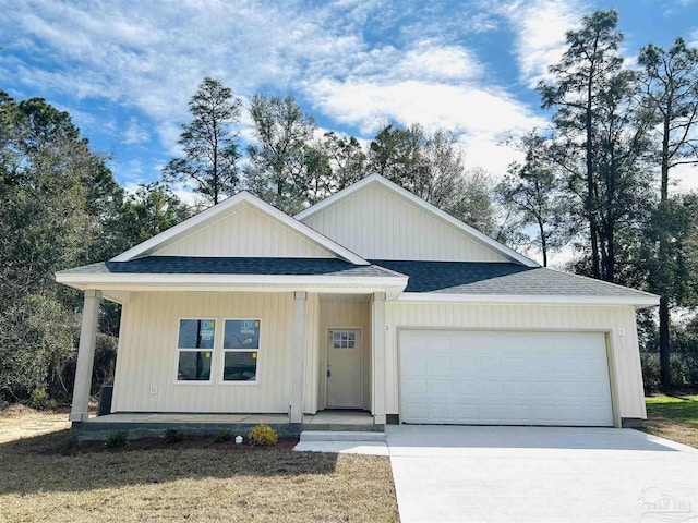 view of front of house featuring an attached garage, covered porch, a shingled roof, and concrete driveway