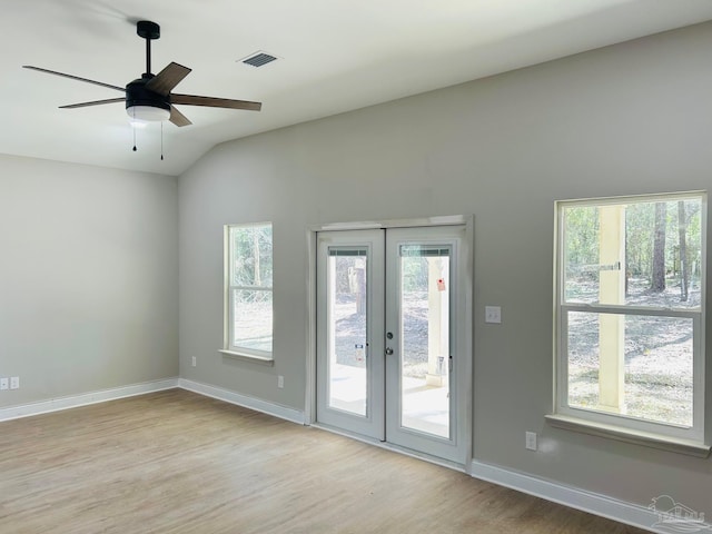 spare room featuring visible vents, baseboards, light wood-style flooring, vaulted ceiling, and french doors