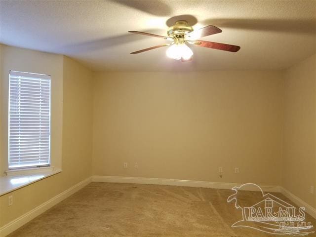 carpeted empty room featuring ceiling fan